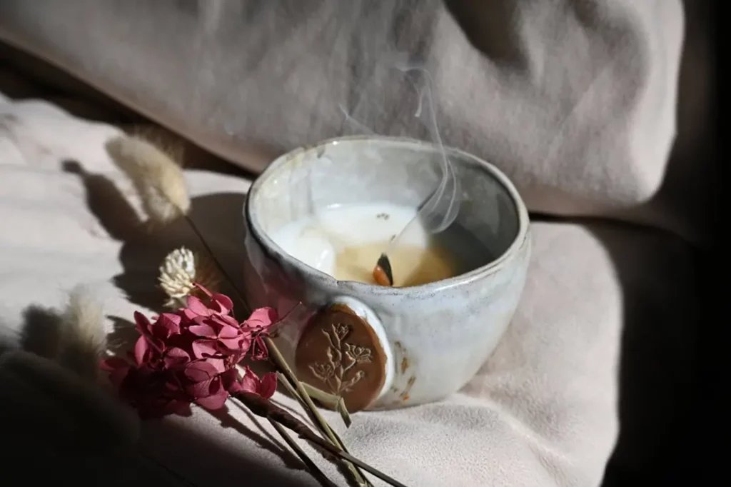 Bol en céramique émaillée avec un médaillon végétal, la mèche fume juste après avoir été soufflée